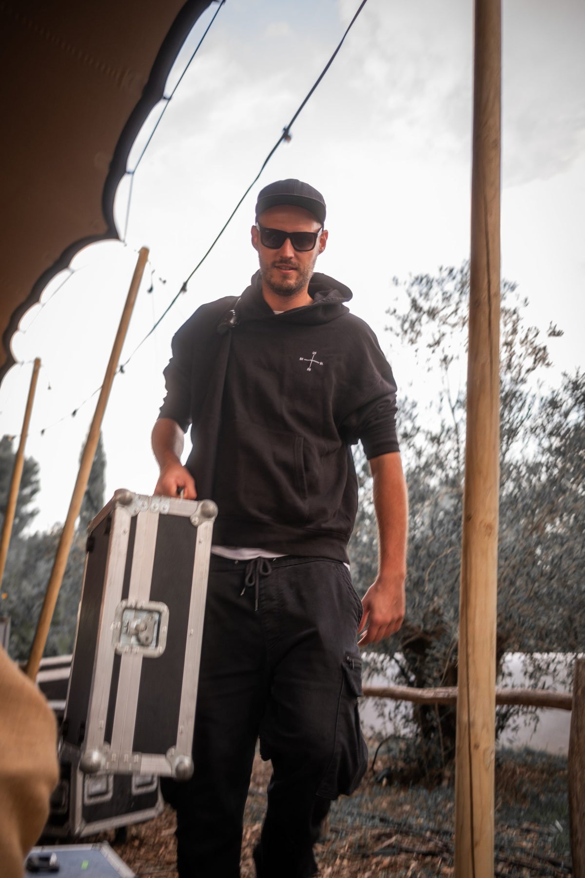 Crew-Mitglied im SL/SR Hoodie trägt ein Flightcase